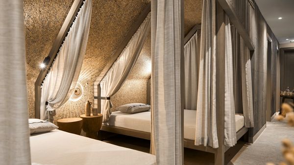 Mit Leinenvorhängen abgetrennte Daybeds im neuen Spa "Schwitzstube" im Platzl Hotel.