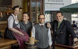 Four Marias Platzl Employees are wearing  traditional Bavarian clothes and are laughing together 