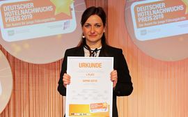 Sophie Gotte is holding up her gold award of the 2019 German Hotel Trainee Awards