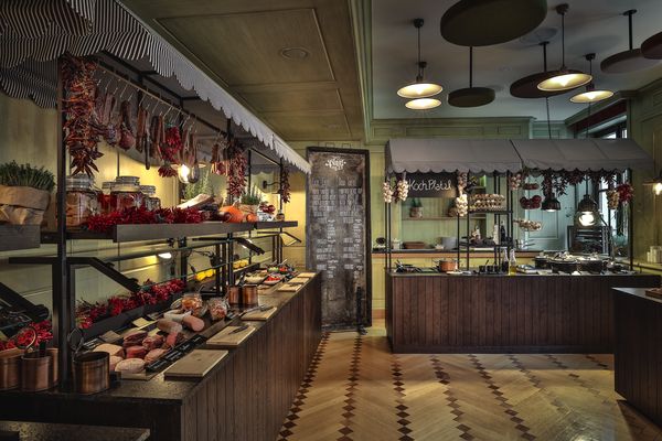 Ein gemütlicher Frühstücksraum verfügt über ein großes Holzbuffet mit Fleisch, Käse, Brot und frischen Kräutern