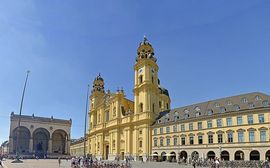 Theatiner Church at Odeonsplatz in Munich in front of a blue sky.