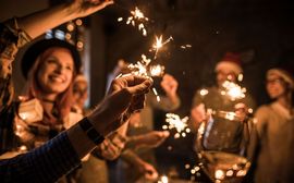 Silvester und Sternwerfer Mehrere Personen auf einer Silvester-Feier halten brennende Wunderkerzen und Sektgläser in die Höhe.