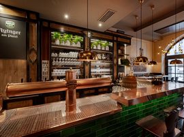 Die Ayinger am Platzl Bar mit Kupferbierhähnen, grünen Fliesen und hängenden Messinglampen