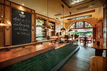 Hölzerner Tresen im Wirtshaus Ayinger in München, im Hintergrund eine bogenförmige Fensterfront